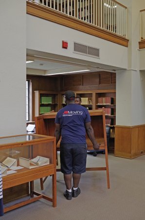 Movers relocate a study carrel.