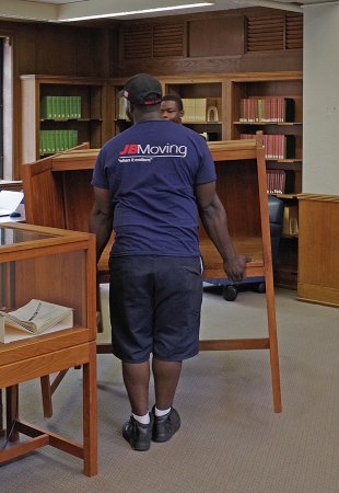 Movers relocate furniture in the Morse Reading Room.