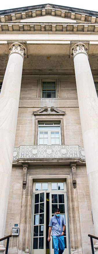 a person in scrubs leaving the school of medicine building