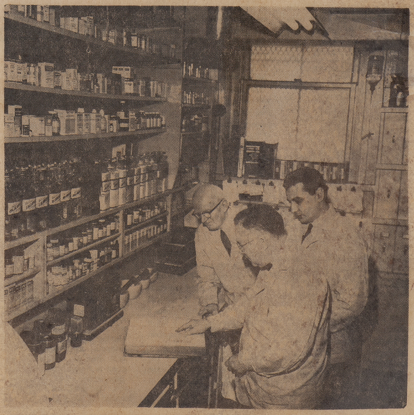 Three pharmacists at the Hall-Benedict Drug Company look 