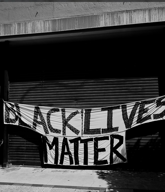 a black and white photo of a garage with a 'black lives matter' affixed to the front