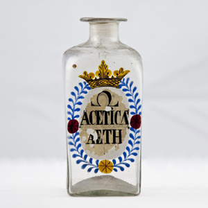 a small clear apothecary jar with a blue label