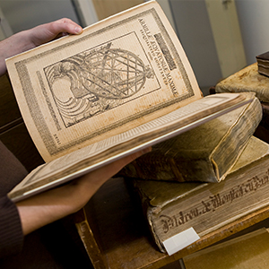 a person holding a rare book open in their hands