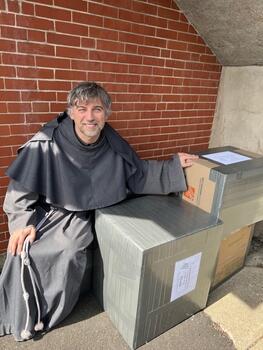 Father Norbert M. Siwinski of St. Michael’s Parish of Bridgeport next to packed medical supplies