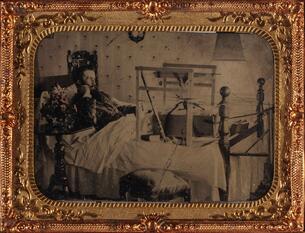 Man in bed with leg in an early traction device, tintype in thermoplastic case, circa 1860-1870