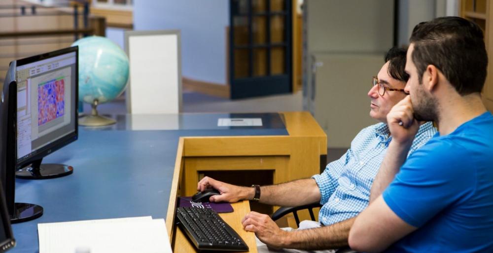 Rolando working with researcher on the high performance computer