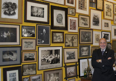 stanley b burns in front of a wall of photographs