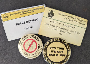 two ID badges with the name polly murray - lyme ct, and two pins that say 'I'm not crazy I just have Lyme' and 'It's time we got tick'd-off'