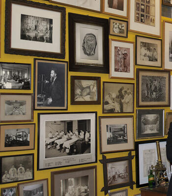 yellow wall displaying framed historic medical photography in various sizes