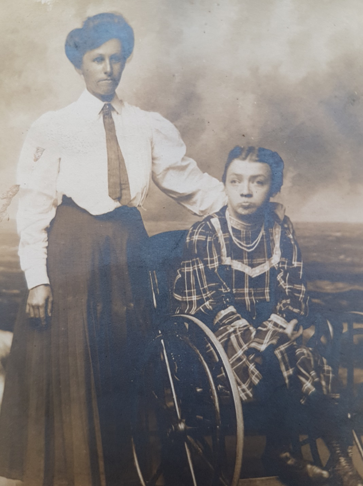 girl in wheelchair next to standing woman