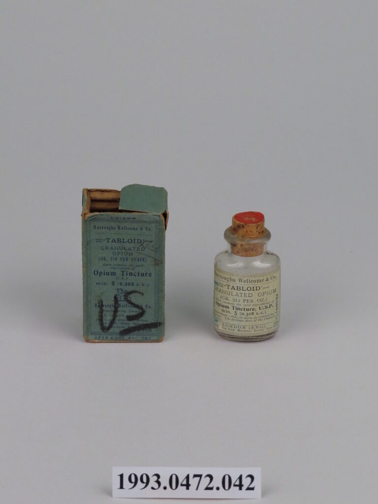 small glass vial next to cardboard holder