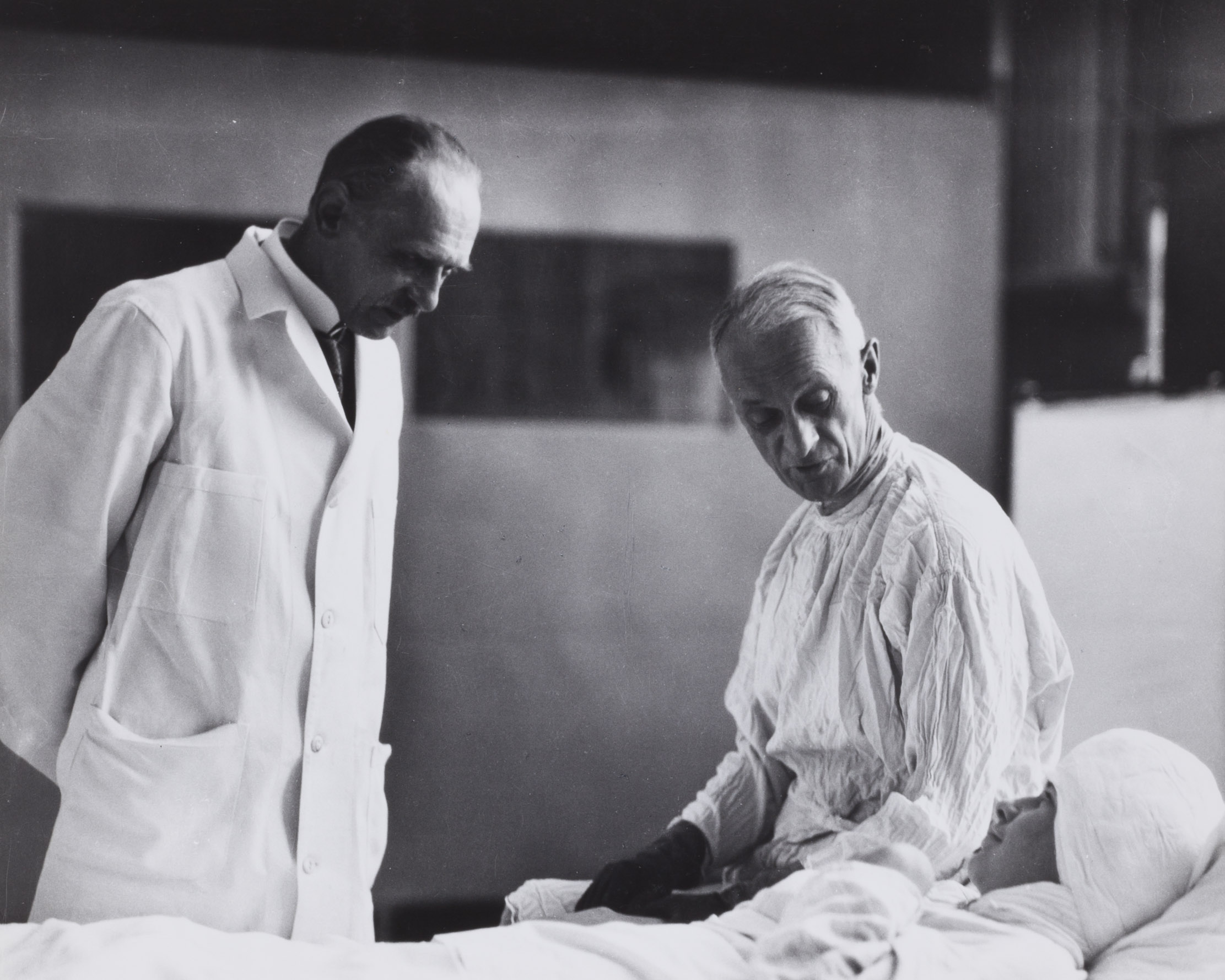 cushing and doctor sit with patient